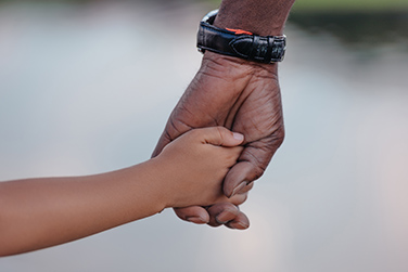 cropped view of african american grandfather holding hands with granddaughter