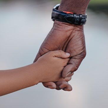 cropped view of african american grandfather holding hands with granddaughter
